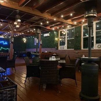 Covered deck dining room at night with string lights at Mezze Cafe Austin