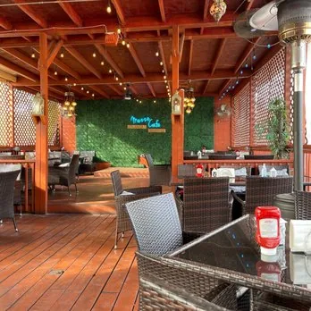 Covered patio by day with the neon sign at Mezze Cafe Austin