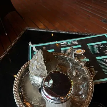 Turkish coffee cezve on a tray beside the menu at Mezze Cafe Austin
